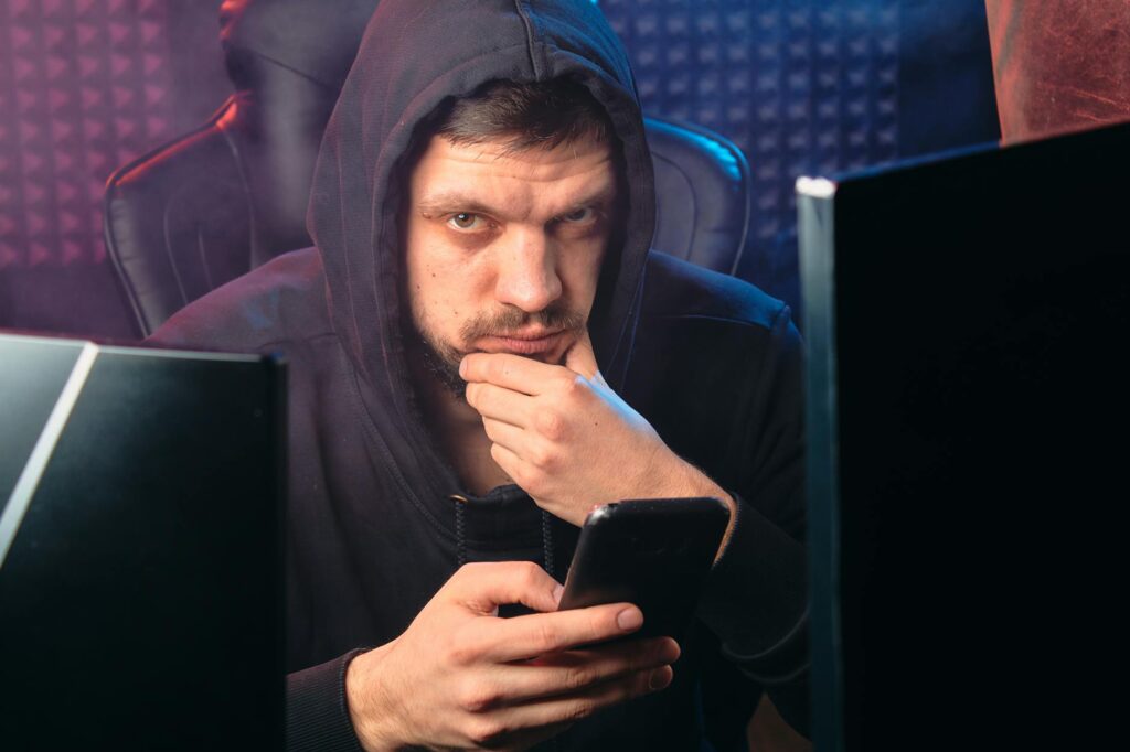 man in black hoodie holding a smartphone